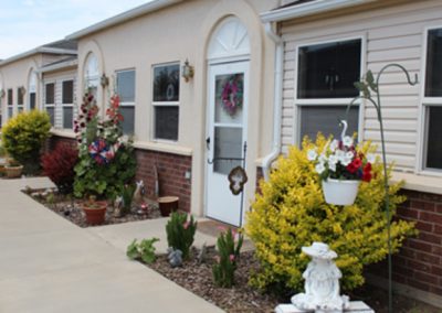 Lovely residential buildings with vibrant flowers and lush plants in the front gardens.