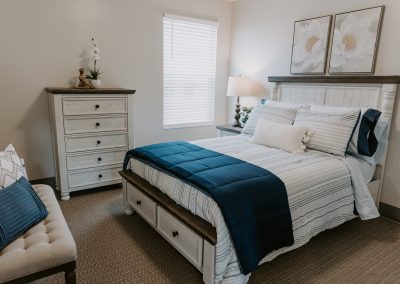 Cozy bedroom with a large bed, nightstands, and a window with curtains, creating a warm and inviting atmosphere.