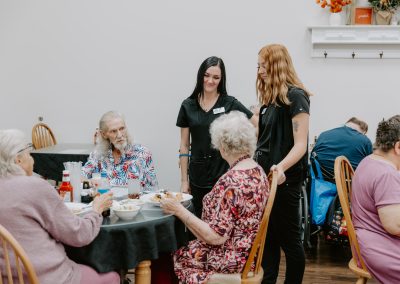 People gathered around a table, savoring a meal, while attentive staff members provide excellent service.