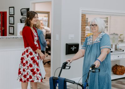 A woman assisting an older woman with a walker, showcasing the Incredible Staff support.